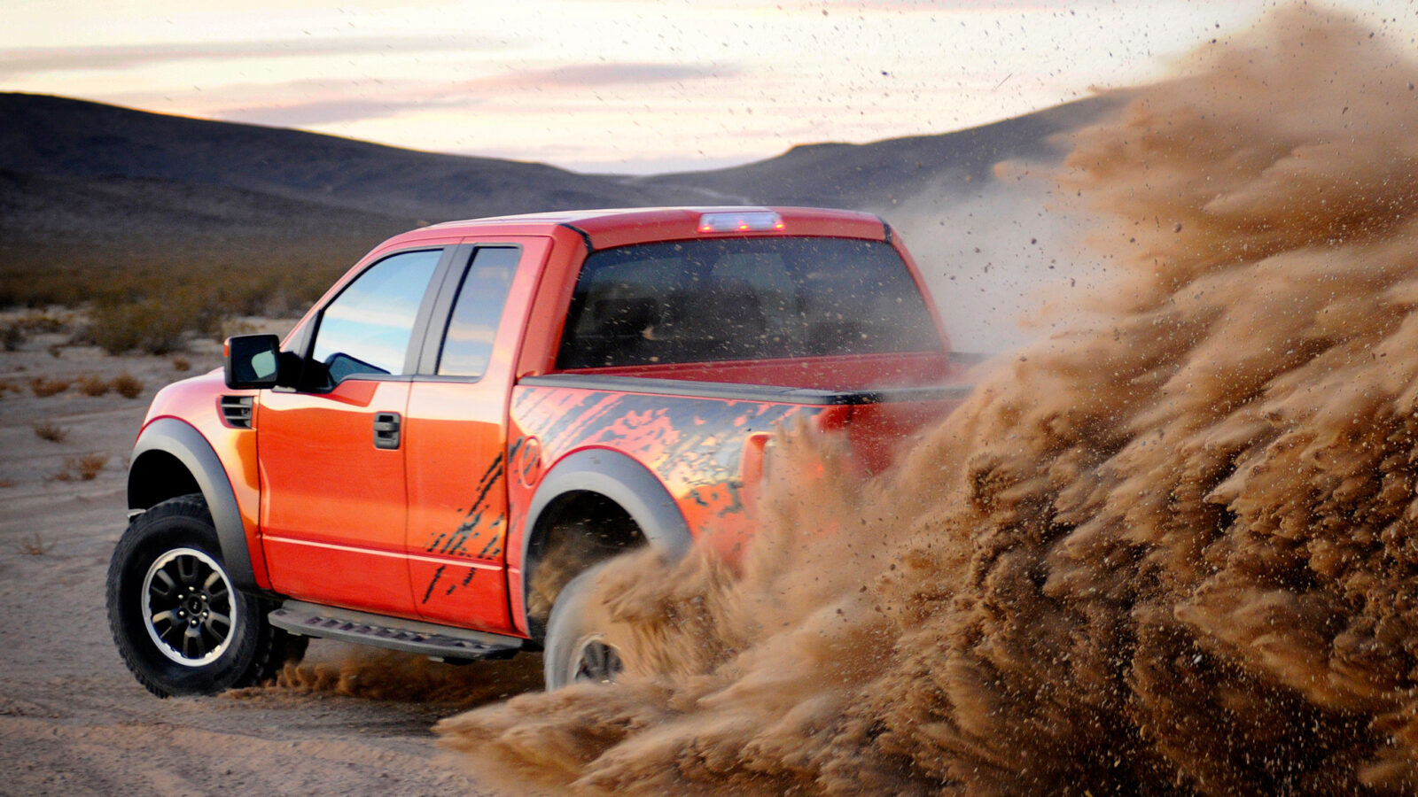 Ford F-150 Raptor kicking up dust off-road