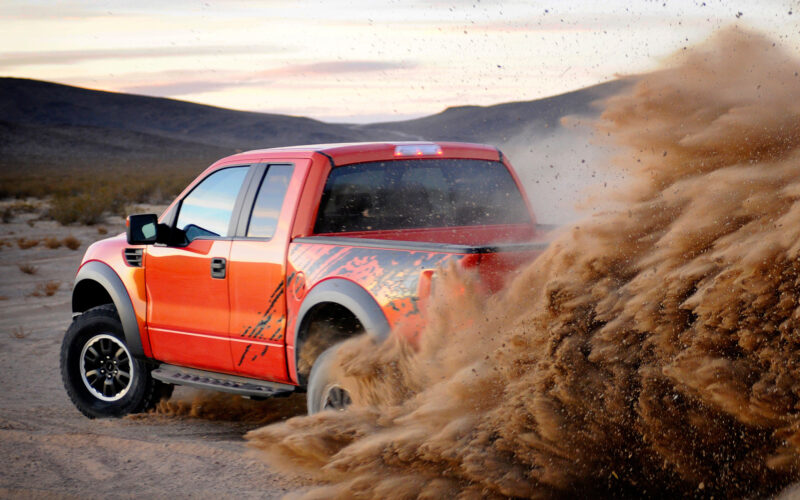 Ford F-150 Raptor kicking up dust off-road